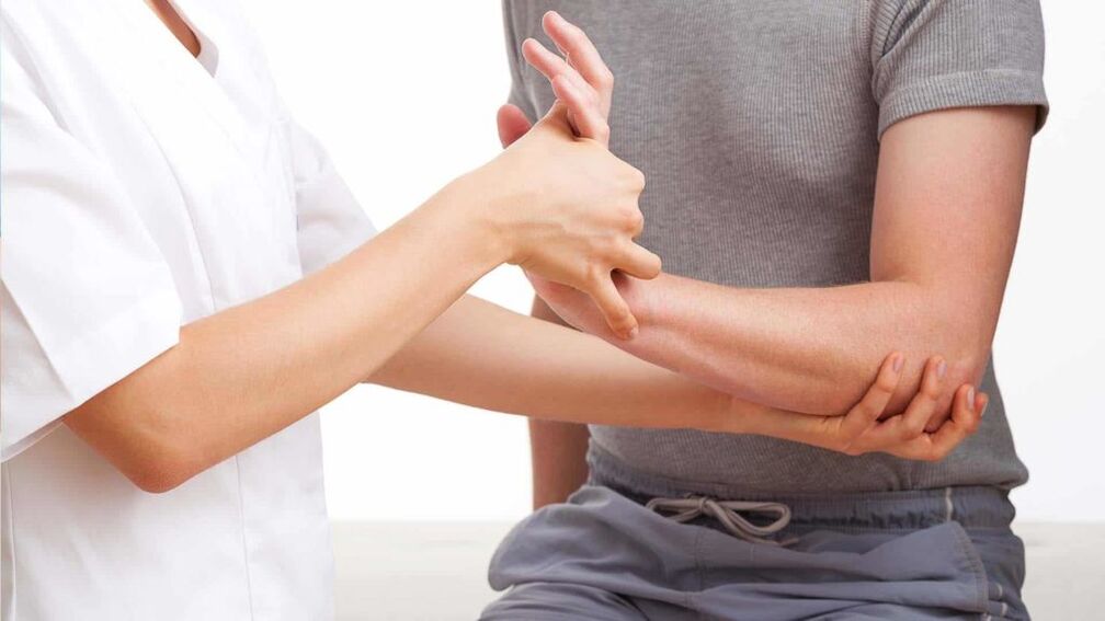 Arzt untersucht eine Hand mit Arthritis